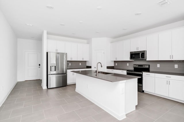 1596 Contentment Loop, Kissimmee, FL 34744 - kitchen with stainless steel appliances, a sink, dark countertops, backsplash, and a center island with sink