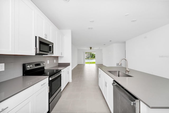 1596 Contentment Loop, Kissimmee, FL 34744 - kitchen with appliances with stainless steel finishes, a sink, decorative backsplash, light tile patterned floors, and open floor plan