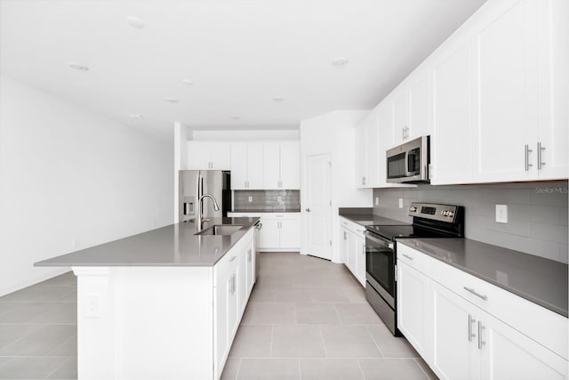 1596 Contentment Loop, Kissimmee, FL 34744 - kitchen with appliances with stainless steel finishes, a sink, light tile patterned flooring, tasteful backsplash, and a center island with sink
