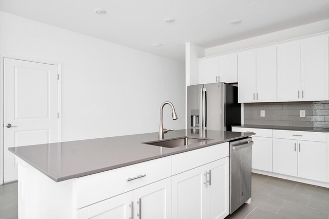 1596 Contentment Loop, Kissimmee, FL 34744 - kitchen with stainless steel appliances, a sink, tasteful backsplash, a center island with sink, and white cabinetry