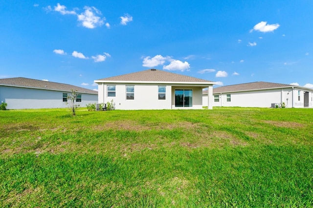 1596 Contentment Loop, Kissimmee, FL 34744 - rear view of property with a yard, stucco siding, and central air condition unit