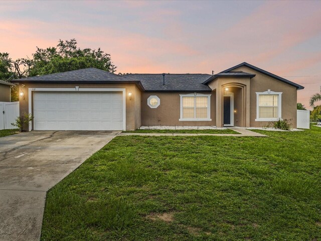 112 Lake Butler Ave, Haines City, FL 33844 - ranch-style home with stucco siding, concrete driveway, an attached garage, and roof with shingles
