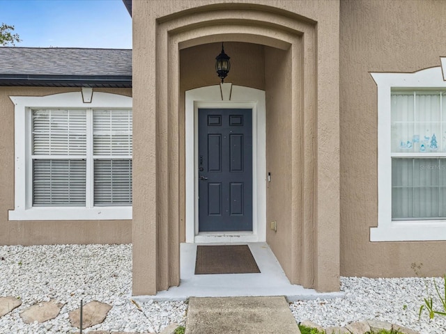 112 Lake Butler Ave, Haines City, FL 33844 - property entrance with stucco siding and a shingled roof