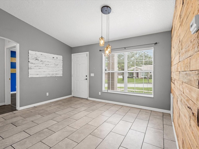 112 Lake Butler Ave, Haines City, FL 33844 - unfurnished dining area featuring a textured ceiling, arched walkways, baseboards, and lofted ceiling