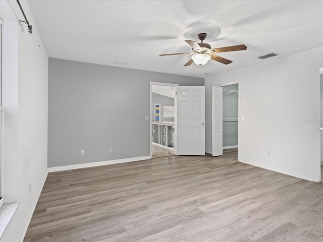 112 Lake Butler Ave, Haines City, FL 33844 - unfurnished bedroom with light wood-type flooring, baseboards, ceiling fan, and a textured ceiling