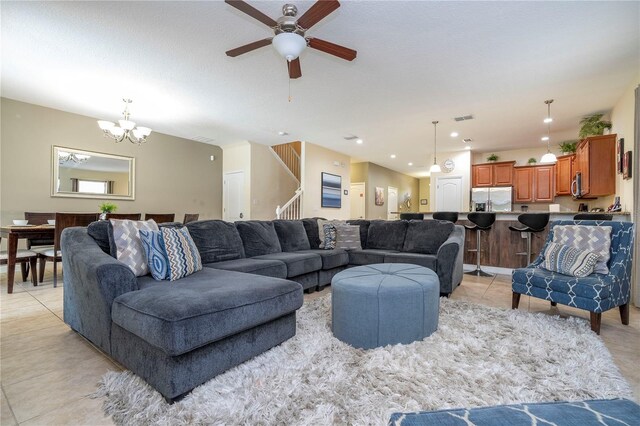 1439 Moon Valley Dr, Davenport, FL 33896 - living room with ceiling fan, light tile patterned floors, stairs, and a chandelier