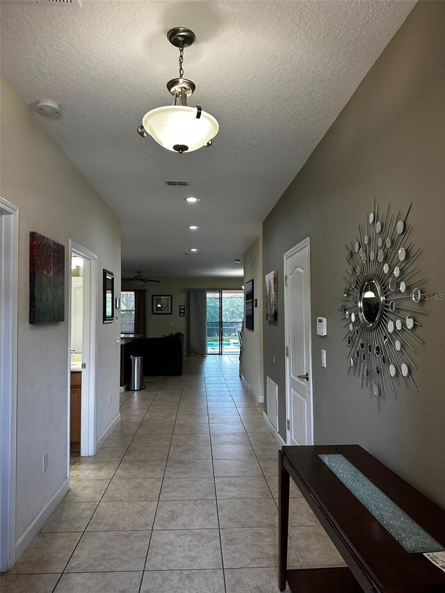 1439 Moon Valley Dr, Davenport, FL 33896 - hallway featuring a textured ceiling, light tile patterned floors, and baseboards