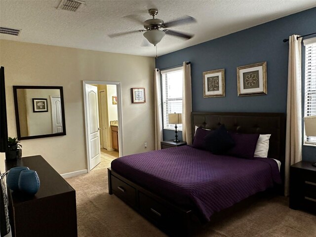 1439 Moon Valley Dr, Davenport, FL 33896 - bedroom with light colored carpet, ceiling fan, ensuite bathroom, and a textured ceiling