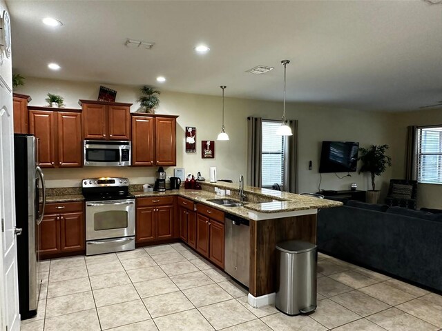 1439 Moon Valley Dr, Davenport, FL 33896 - kitchen with appliances with stainless steel finishes, open floor plan, a peninsula, a sink, and stone counters