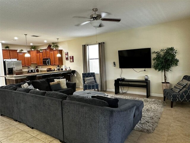 1439 Moon Valley Dr, Davenport, FL 33896 - living area featuring a ceiling fan, light tile patterned floors, and baseboards