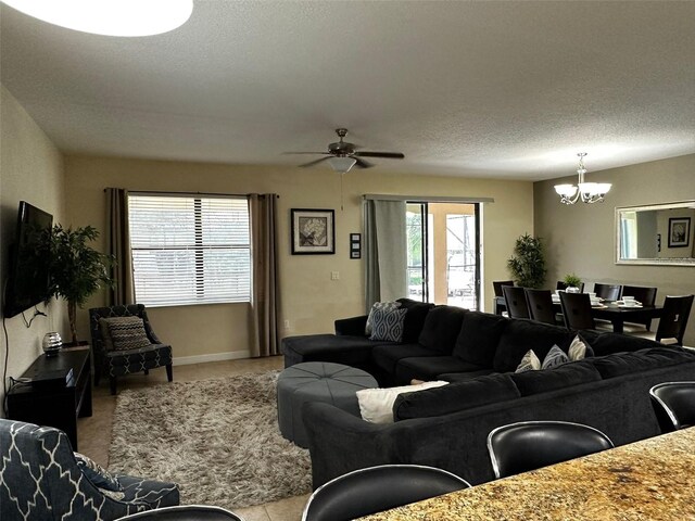 1439 Moon Valley Dr, Davenport, FL 33896 - carpeted living room with a chandelier, a ceiling fan, baseboards, and a textured ceiling