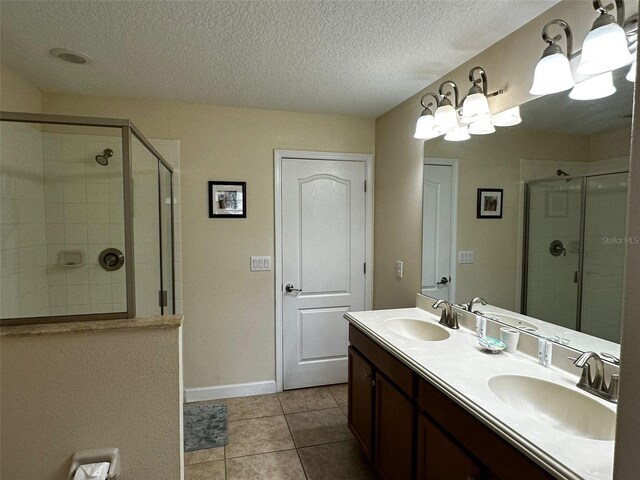 1439 Moon Valley Dr, Davenport, FL 33896 - bathroom with a stall shower, double vanity, tile patterned floors, a textured ceiling, and baseboards