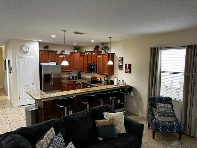 1439 Moon Valley Dr, Davenport, FL 33896 - kitchen featuring stainless steel appliances, light tile patterned floors, a peninsula, open floor plan, and recessed lighting