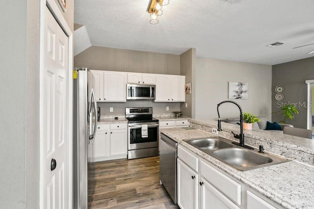 17516 Blessing Dr, Clermont, FL 34714 - kitchen featuring appliances with stainless steel finishes, a sink, dark wood-type flooring, white cabinetry, and light countertops