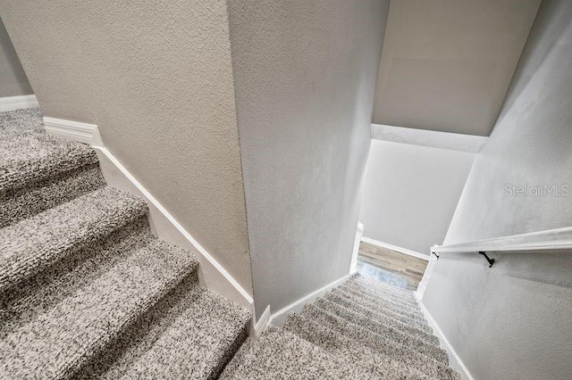 17516 Blessing Dr, Clermont, FL 34714 - staircase with a textured wall and baseboards