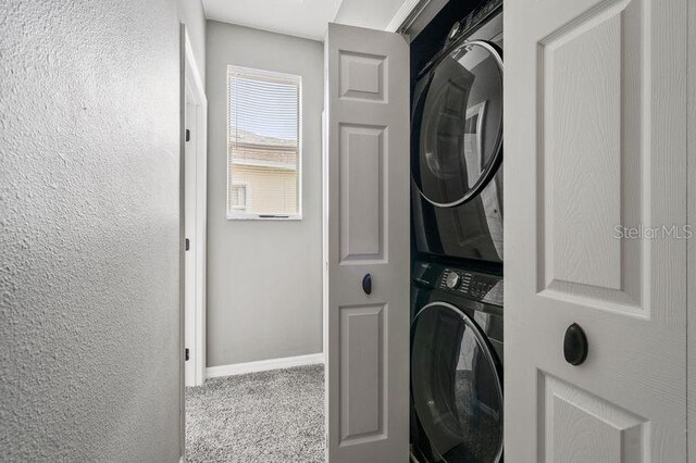 17516 Blessing Dr, Clermont, FL 34714 - laundry area with stacked washer / dryer, carpet floors, baseboards, and a textured wall