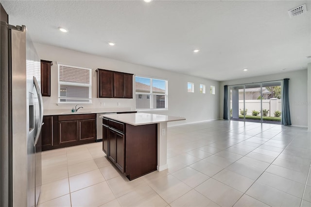 2578 Cliff Way, Saint Cloud, FL 34771 - kitchen featuring appliances with stainless steel finishes, open floor plan, a center island, a sink, and light countertops