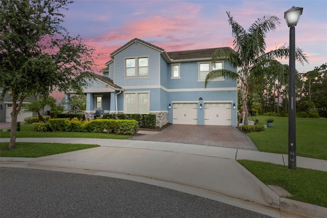 9844 Beach Port Dr, Winter Garden, FL 34787 - view of front of home featuring a garage, driveway, a yard, stucco siding, and stone siding
