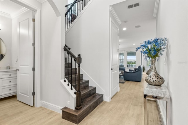 9844 Beach Port Dr, Winter Garden, FL 34787 - staircase with ornamental molding, wood finished floors, baseboards, arched walkways, and recessed lighting