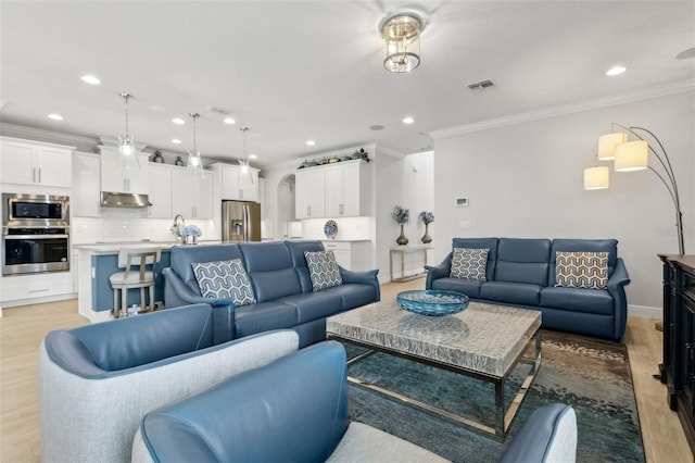 9844 Beach Port Dr, Winter Garden, FL 34787 - living area featuring ornamental molding, recessed lighting, light wood finished floors, arched walkways, and baseboards