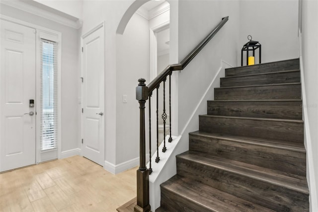 9844 Beach Port Dr, Winter Garden, FL 34787 - entryway featuring arched walkways, light wood-type flooring, baseboards, and stairs