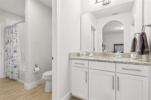 9844 Beach Port Dr, Winter Garden, FL 34787 - bathroom with vanity, toilet, wood finished floors, baseboards, and shower / tub combo