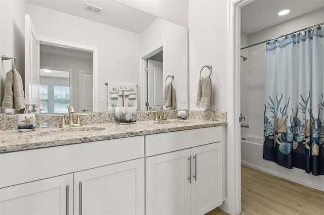 9844 Beach Port Dr, Winter Garden, FL 34787 - bathroom featuring double vanity, shower / tub combo with curtain, and wood finished floors