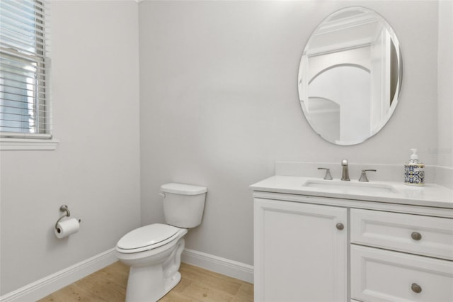 9844 Beach Port Dr, Winter Garden, FL 34787 - half bathroom with vanity, toilet, baseboards, and wood finished floors