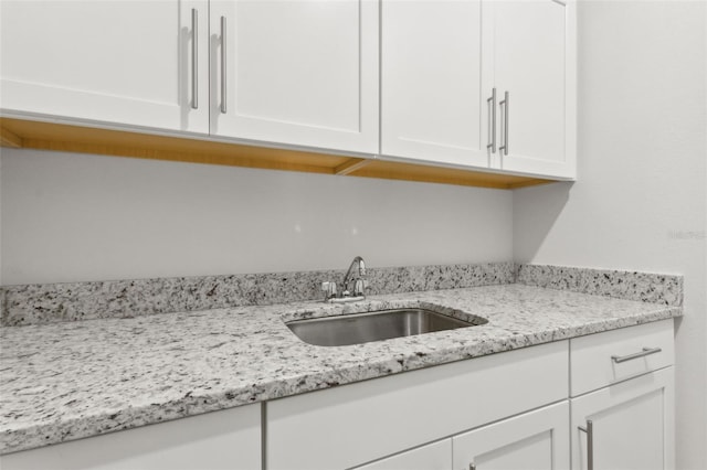 9844 Beach Port Dr, Winter Garden, FL 34787 - kitchen featuring a sink, white cabinetry, and light stone countertops