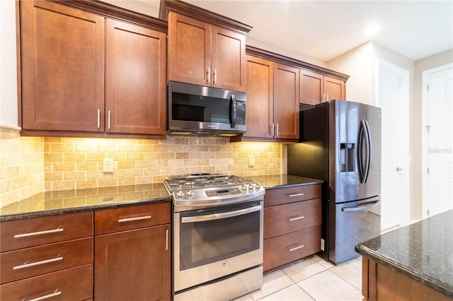3651 NW 56th Ave, Ocala, FL 34482 - kitchen featuring stainless steel appliances, dark stone counters, decorative backsplash, light tile patterned floors, and brown cabinets