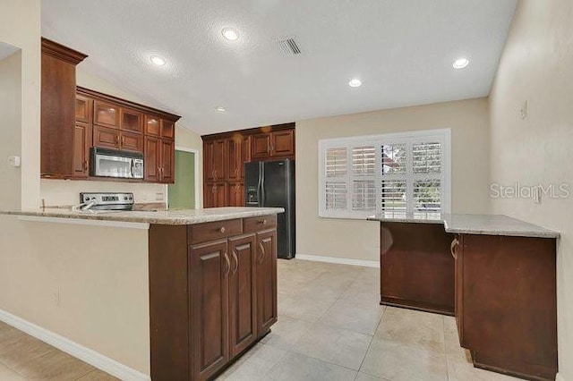 9319 Woodbreeze Blvd, Windermere, FL 34786 - kitchen with appliances with stainless steel finishes, a peninsula, baseboards, glass insert cabinets, and vaulted ceiling