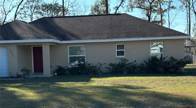 7047 SW 131st Loop, Ocala, FL 34473 - view of home's exterior with stucco siding, a shingled roof, and a yard