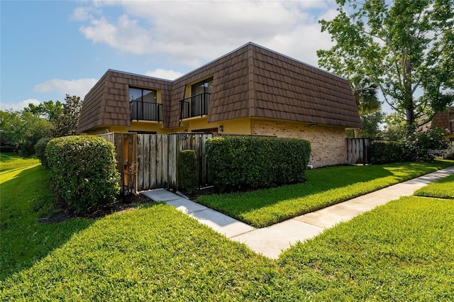 5287 Cypress Ct Unit 724, Orlando, FL 32811 - view of home's exterior with mansard roof, brick siding, and a balcony