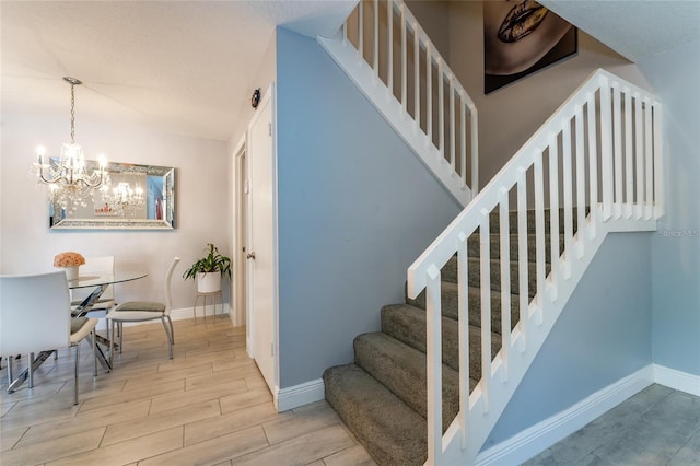 5287 Cypress Ct Unit 724, Orlando, FL 32811 - stairway featuring wood finished floors and a chandelier