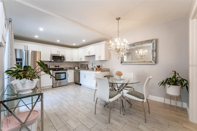 5287 Cypress Ct Unit 724, Orlando, FL 32811 - kitchen featuring appliances with stainless steel finishes, a chandelier, wood tiled floors, white cabinets, and recessed lighting