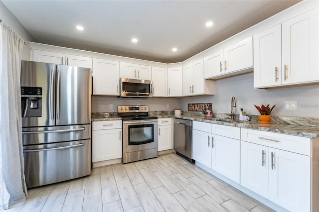 5287 Cypress Ct Unit 724, Orlando, FL 32811 - kitchen featuring stainless steel appliances, white cabinets, stone countertops, and recessed lighting