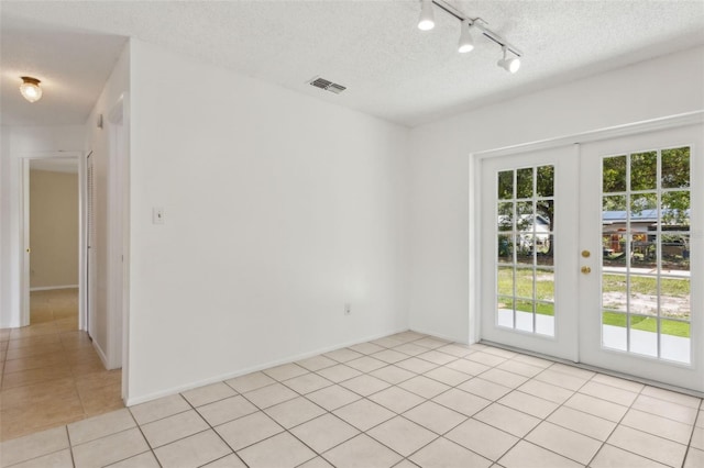 325 Little Aspen Ct, Ocoee, FL 34761 - empty room featuring light tile patterned flooring, a textured ceiling, track lighting, and french doors