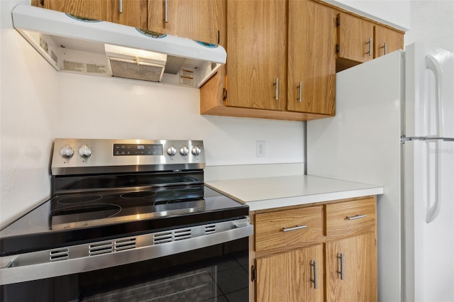 325 Little Aspen Ct, Ocoee, FL 34761 - kitchen with stainless steel electric range oven, under cabinet range hood, light countertops, brown cabinetry, and tile patterned floors