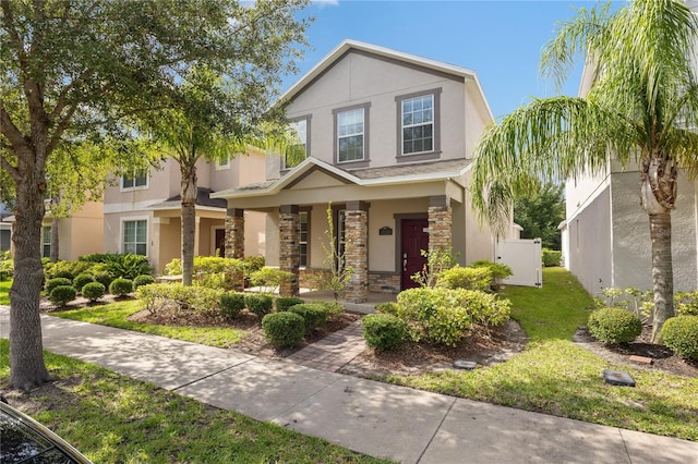 15229 Evergreen Oak Loop, Winter Garden, FL 34787 - view of front facade featuring stucco siding, stone siding, and a porch