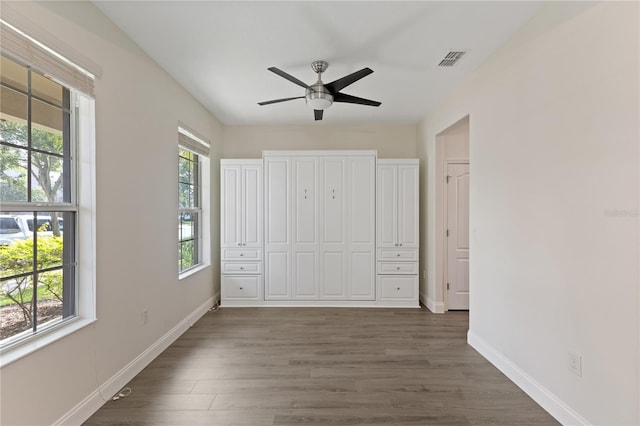 15229 Evergreen Oak Loop, Winter Garden, FL 34787 - unfurnished bedroom featuring dark wood-type flooring, baseboards, and a ceiling fan