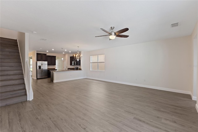 15229 Evergreen Oak Loop, Winter Garden, FL 34787 - unfurnished living room featuring a chandelier, a ceiling fan, stairway, baseboards, and wood finished floors