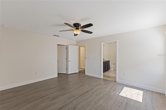 15229 Evergreen Oak Loop, Winter Garden, FL 34787 - unfurnished bedroom featuring wood finished floors, baseboards, connected bathroom, and ceiling fan