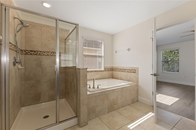 15229 Evergreen Oak Loop, Winter Garden, FL 34787 - bathroom featuring a bath, a stall shower, tile patterned flooring, and baseboards