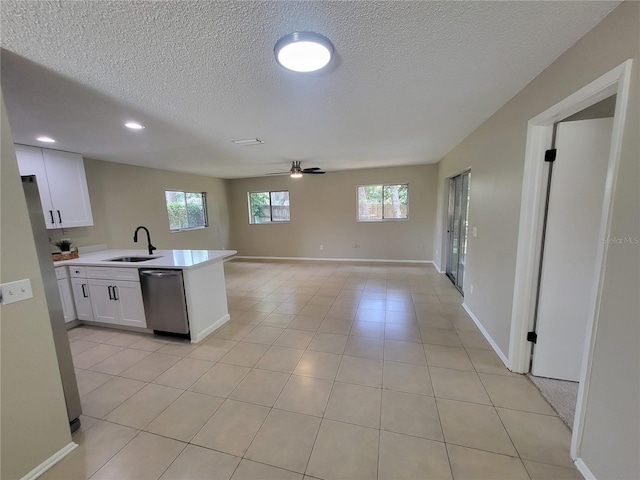 4883 Cherokee Rose Dr, Orlando, FL 32808 - kitchen with a sink, dishwasher, white cabinets, light countertops, and healthy amount of natural light