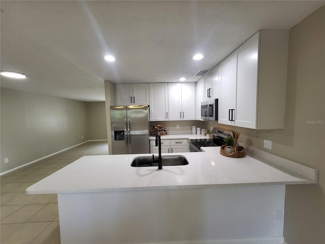 4883 Cherokee Rose Dr, Orlando, FL 32808 - kitchen with stainless steel appliances, a sink, recessed lighting, a peninsula, and white cabinets