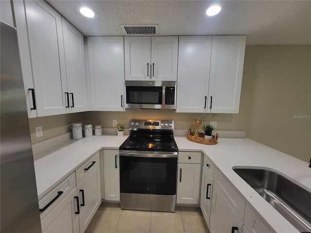 4883 Cherokee Rose Dr, Orlando, FL 32808 - kitchen with stainless steel appliances, a sink, light countertops, white cabinetry, and recessed lighting