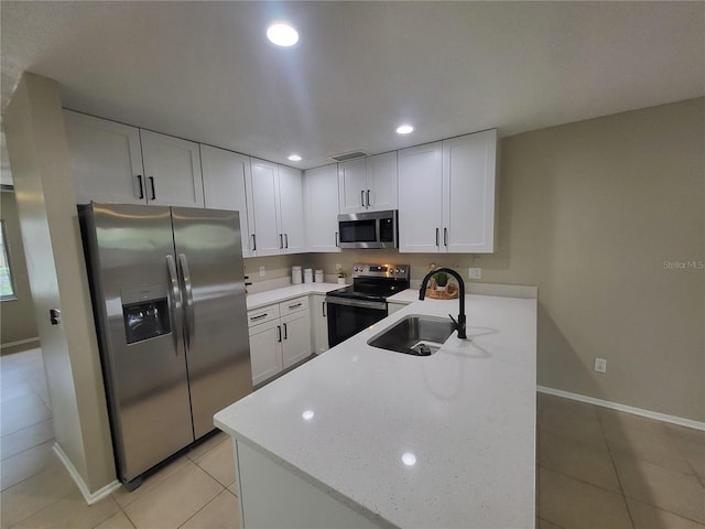 4883 Cherokee Rose Dr, Orlando, FL 32808 - kitchen featuring appliances with stainless steel finishes, a sink, baseboards, a peninsula, and light tile patterned floors