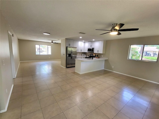 4883 Cherokee Rose Dr, Orlando, FL 32808 - kitchen with appliances with stainless steel finishes, open floor plan, ceiling fan, a textured ceiling, and light tile patterned floors