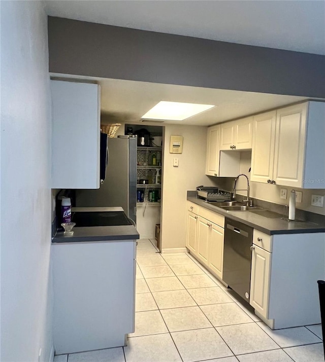 1815 Townhall Ln Unit 1815, Orlando, FL 32807 - kitchen with dishwasher, a sink, light tile patterned floors, dark countertops, and white cabinets