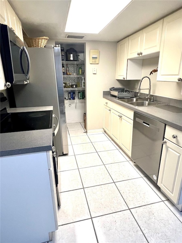 1815 Townhall Ln Unit 1815, Orlando, FL 32807 - kitchen with appliances with stainless steel finishes, a sink, light tile patterned flooring, and dark countertops